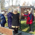 Seniorzy stoją obok Tablicy informującej o zabytkach Łukowicy