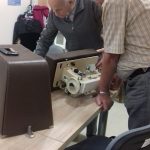 dwóch seniorów naprawia maszynę do szycia