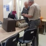 dwóch seniorw naprawia maszynę do szycia